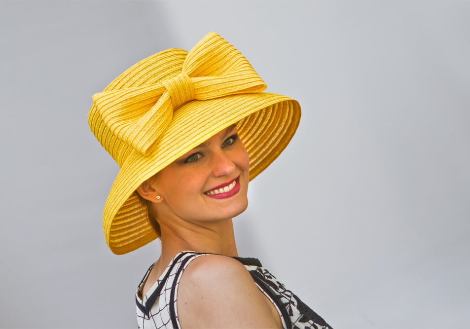Eine Besucherin des Internationalen Oldtimertreffens mit einem großen, gelben Hut