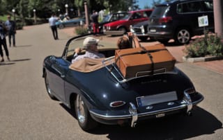 Teilnehmer des Internationalen Oldtimer-Meetings in ihrem Oldtimer auf dem Weg zur gemeinsamen Ausfahrt